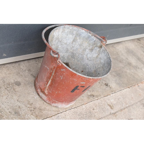 344 - Vintage metal riveted fire bucket with swing-over handle painted red with 'FIRE' in black, 31cm tall... 