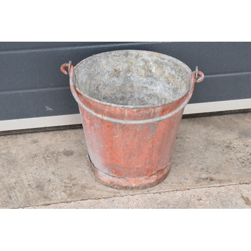 344 - Vintage metal riveted fire bucket with swing-over handle painted red with 'FIRE' in black, 31cm tall... 