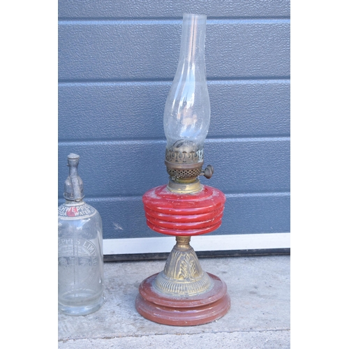 348 - Early to mid 20th century brass oil lamp with red glass reservoir together with a vintage fuel can a... 