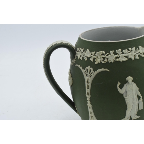 82 - Early Wedgwood green Jasperware ovoid jug with traditional scenes, 15cm tall.