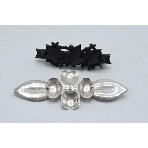 205I - A pair of vintage brooches to include white metal stylised floral brooch and a vulcanite ivy brooch ... 