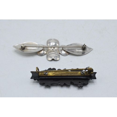 205I - A pair of vintage brooches to include white metal stylised floral brooch and a vulcanite ivy brooch ... 