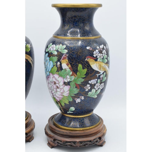 238 - A boxed pair of Chinese cloisonne vases with birds amongst foliage with rich blue background on wood... 