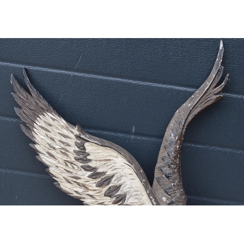 248 - A cast metal wall plaque of an eagle carrying a fish, 67cm tall.