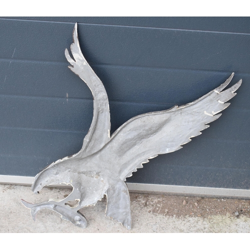 248 - A cast metal wall plaque of an eagle carrying a fish, 67cm tall.