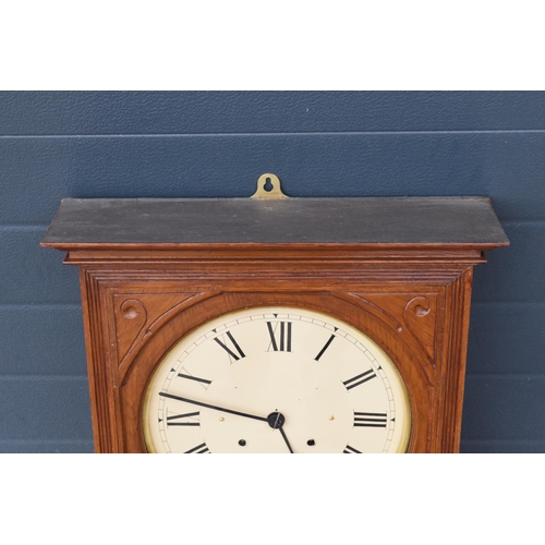 312 - 20th century wooden cased wall clock, in the style of Seth Thomas, with key and pendulum. 58cm long.