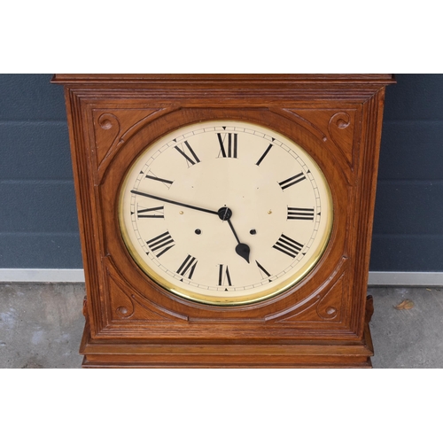 312 - 20th century wooden cased wall clock, in the style of Seth Thomas, with key and pendulum. 58cm long.