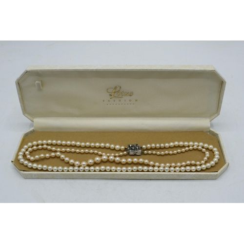 180 - A pair of single row cultured pearl necklaces, one with silver clasp (2).