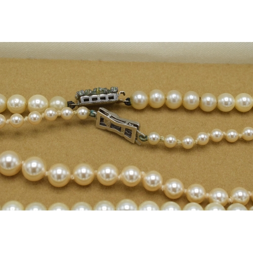 180 - A pair of single row cultured pearl necklaces, one with silver clasp (2).