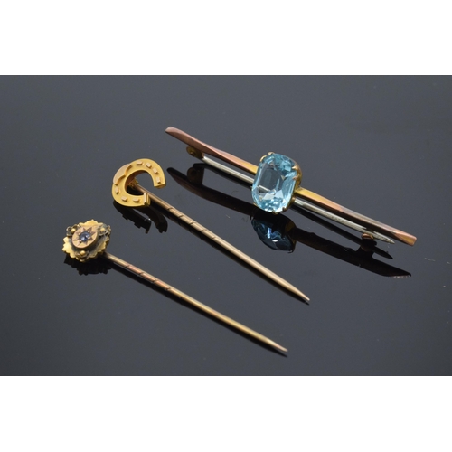 194 - A trio of 9ct gold jewellery to include 9ct gold sapphire set stick pin, 9ct gold horse shoe and met... 