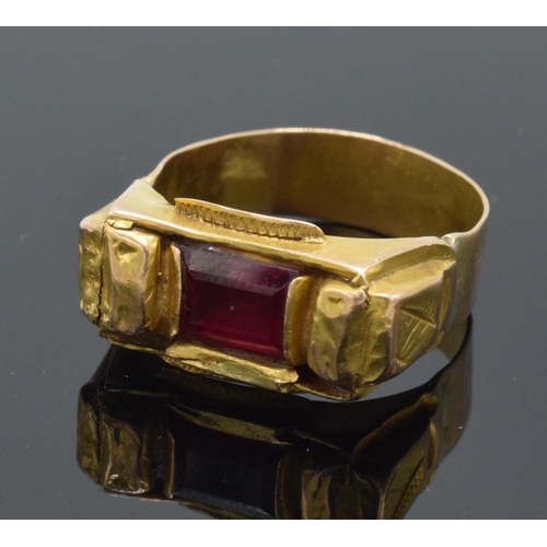 242 - High carat gold ring (22ct +) set with a red stone. 4.7 grams gross weight. UK size V/W.