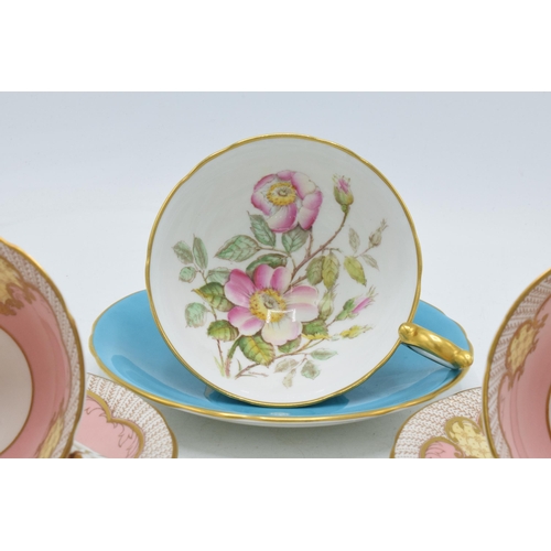 40 - A trio of Aynsley cups and saucers to include Wild Rose pattern on blue background together with 2 p... 