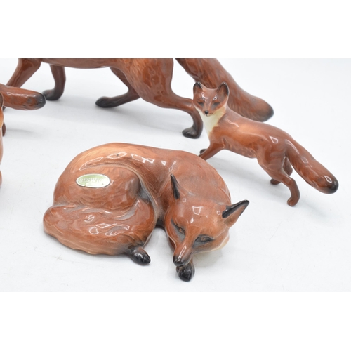 60A - A collection of Beswick foxes to include large standing fox 1016, curled fox 1017, and 3 others (5).