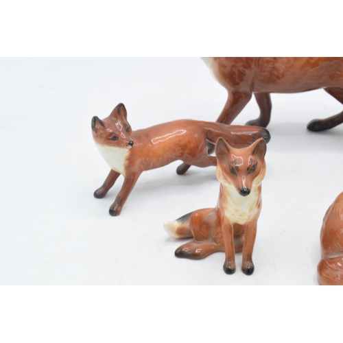 60A - A collection of Beswick foxes to include large standing fox 1016, curled fox 1017, and 3 others (5).