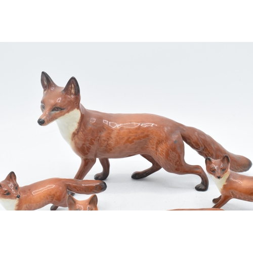 60A - A collection of Beswick foxes to include large standing fox 1016, curled fox 1017, and 3 others (5).