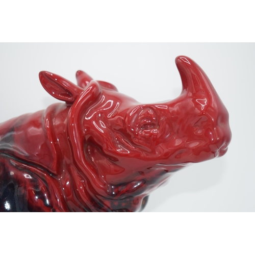 118 - Large Royal Doulton veined flambe model of a seated rhino, 42cm long.