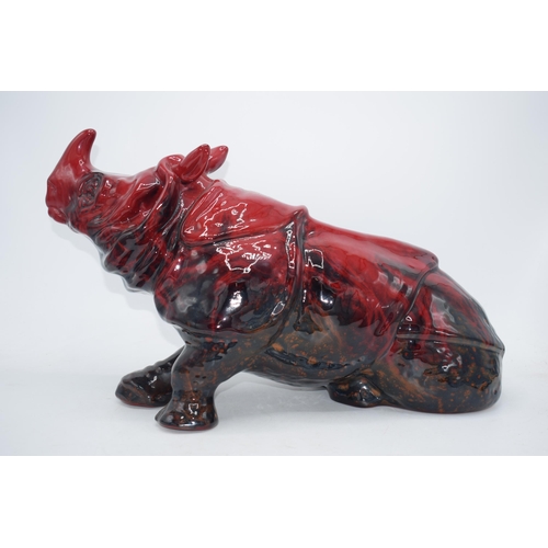 118 - Large Royal Doulton veined flambe model of a seated rhino, 42cm long.