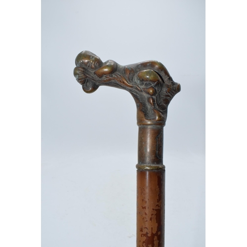 322A - Unusual malacquer (or similar) walking cane with bronze moulded putti handle, 87cm long.