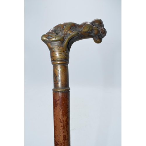 322A - Unusual malacquer (or similar) walking cane with bronze moulded putti handle, 87cm long.