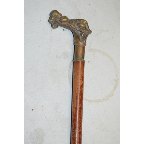 322A - Unusual malacquer (or similar) walking cane with bronze moulded putti handle, 87cm long.