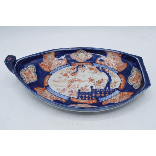 328 - 19th century Imari pottery dish in the form of a shallow boat with traditional scenes, 32cm long.