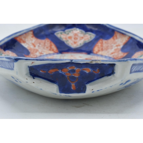 328 - 19th century Imari pottery dish in the form of a shallow boat with traditional scenes, 32cm long.