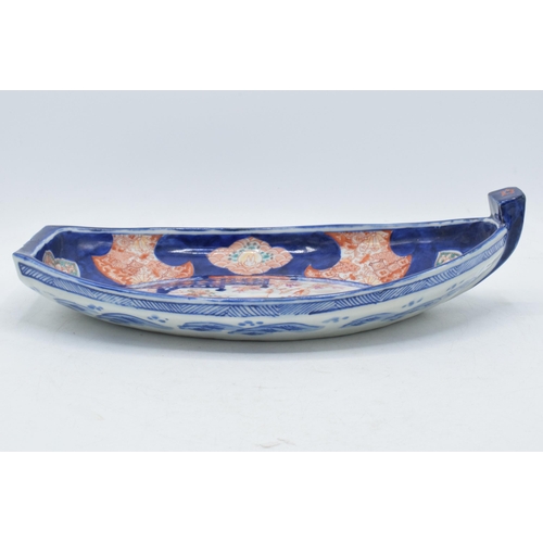 328 - 19th century Imari pottery dish in the form of a shallow boat with traditional scenes, 32cm long.