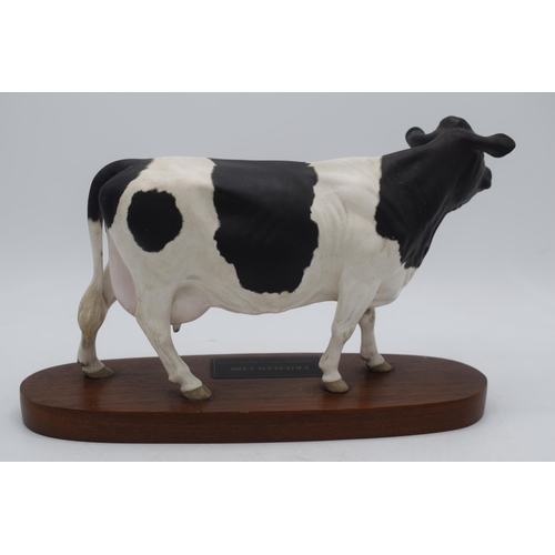 73 - Beswick Friesian Cow Connoisseur model on wooden base A2607 (left ear chipped).