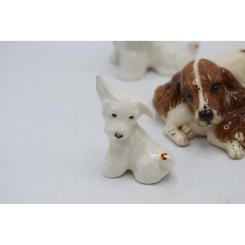 76 - A collection of Beswick and Royal Doulton dogs to include Sealyham Terriers, Beagles and lying Spani... 