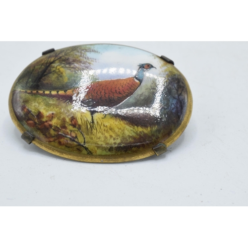 98 - Painted oval porcelain brooch depicting pheasants in the woodland, signed R Hague, possibly for Mint... 