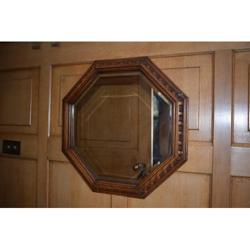 399 - 1930s octagonal oak carved mirror, 63cm diameter, together with a similar fire screen, 72cm tall (2)... 