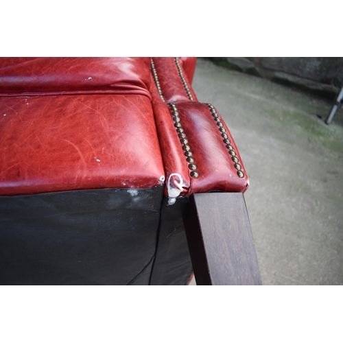 401 - Red leather chesterfield-style leather high-backed arm chair with beaded design, 90x90x97cm tall.