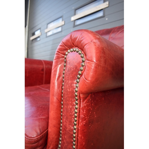 401 - Red leather chesterfield-style leather high-backed arm chair with beaded design, 90x90x97cm tall.