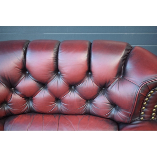 405 - Red oxblood leather Chesterfield-style button-back armchair with metal beading, 110x96x92cm tall.