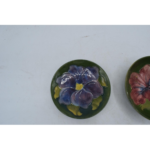 102M - Moorcroft items in the Hibiscus design to include a shallow bowl and a pin tray, 12cm diameter (2).