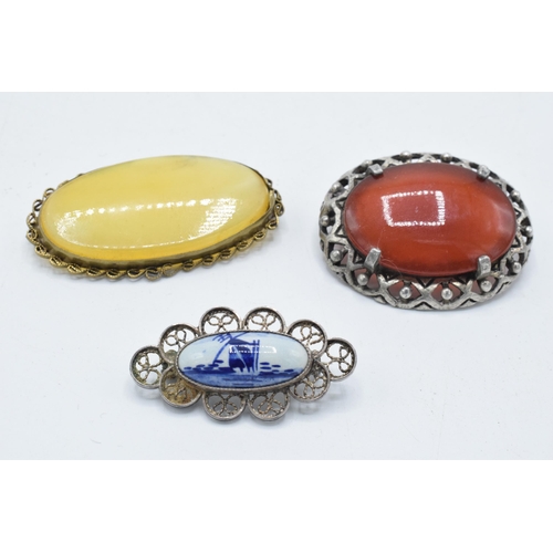 180M - A pair of agate-style framed brooches together with a Delft brooch (3).