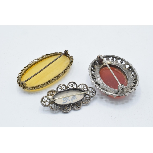 180M - A pair of agate-style framed brooches together with a Delft brooch (3).