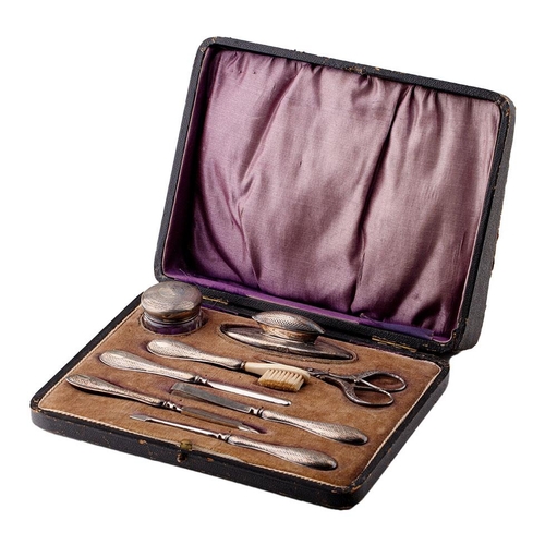 122 - Silver handled manicure set with 8 pieces to include a nail buffer, lidded jar, nail file and others... 