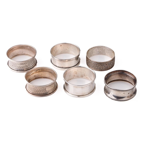 125 - A collection of hallmarked silver napkin rings with varying designs, 59.6 grams (6).