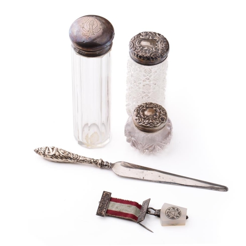 131 - A trio of silver topped scent bottles together with silver handled knife and a medal with a silver b... 