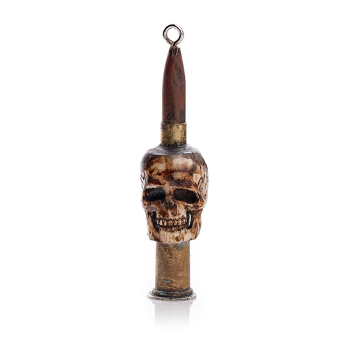 248 - Vintage Trench Art of a carved bone in the form of a skull with an ammunition shell, 9cm tall, mount... 