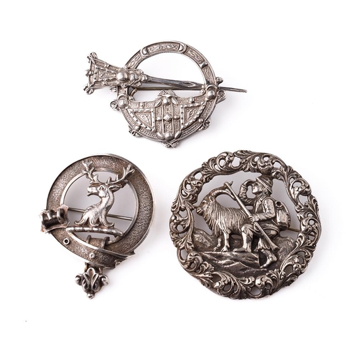 399 - A large silver 830s Scandinavian brooch with traditional scenes together with a Scottish deer brooch... 