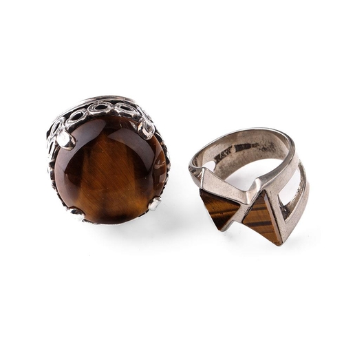 405 - Silver chunky ornate ring set with large tiger's eye together with a modernist similar example (2).