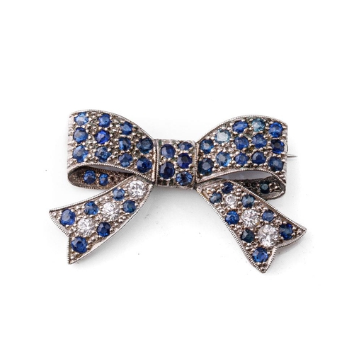 417 - 14ct white gold (tests as) brooch in the form of a bow, set with white and blue sapphires, 6.0 grams... 