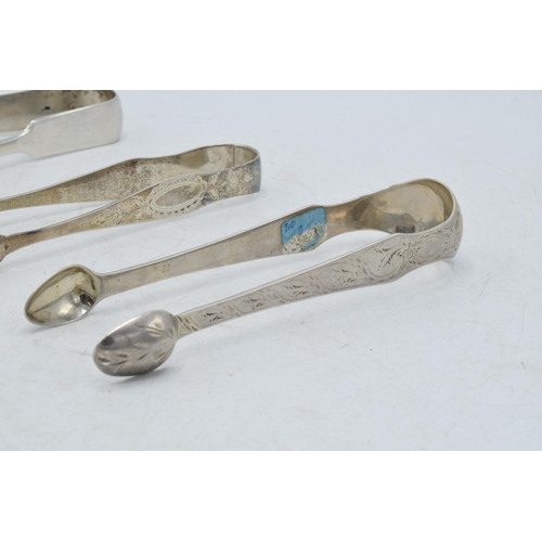 100 - A trio of Georgian sugar tongs, with varying designs to include a floral scene, 131.0 grams.