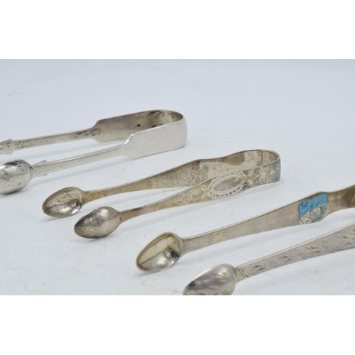 100 - A trio of Georgian sugar tongs, with varying designs to include a floral scene, 131.0 grams.