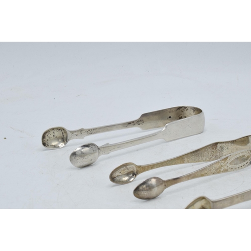 100 - A trio of Georgian sugar tongs, with varying designs to include a floral scene, 131.0 grams.