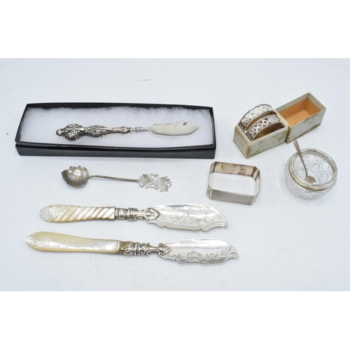 105 - A collection of silver items to include a pair of silver and Mother of Pearl handled fish knives, Bi... 