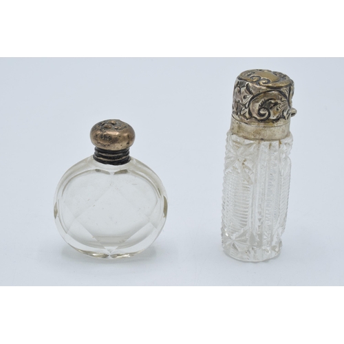 107 - A pair of silver topped scent bottles, one with oval shape, the other bright-cut glass, both early 2... 