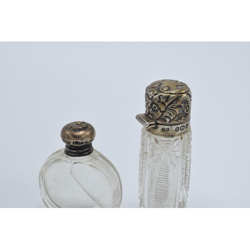 107 - A pair of silver topped scent bottles, one with oval shape, the other bright-cut glass, both early 2... 